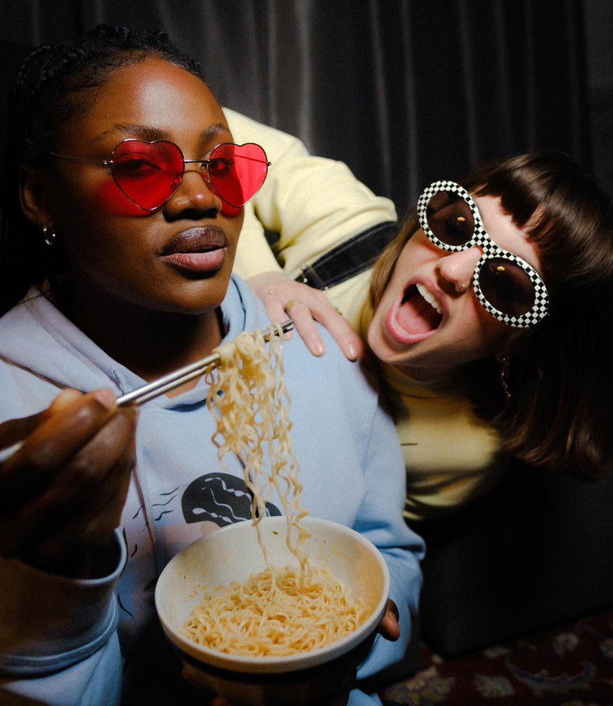 Femmes portant des sweatshirts Freeed et mangeant des nouilles